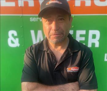 SERVPRO employee in front of SERVPRO background