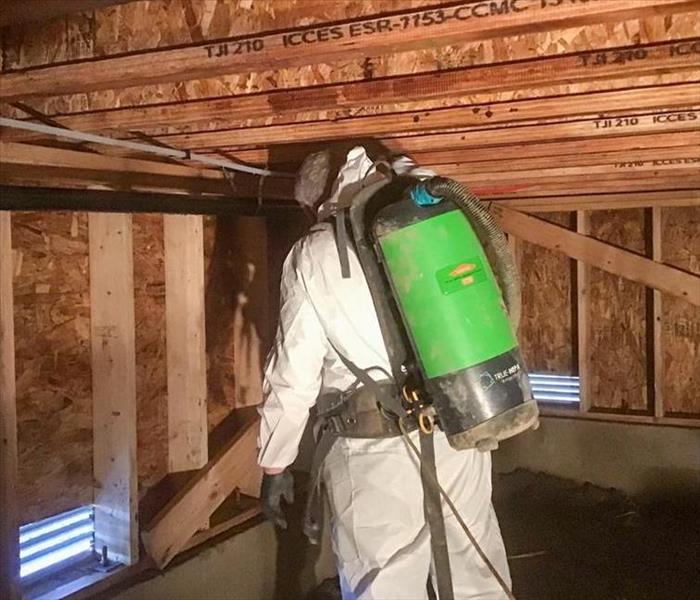 SERVPRO employee in PPE cleaning a structure